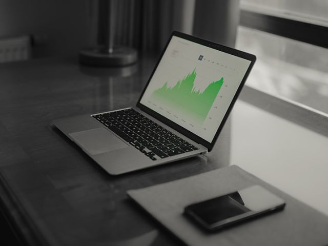 Laptop on table with stock chart